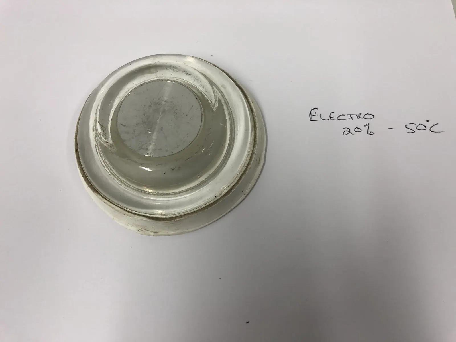 Lens photographed beside its handwritten process card