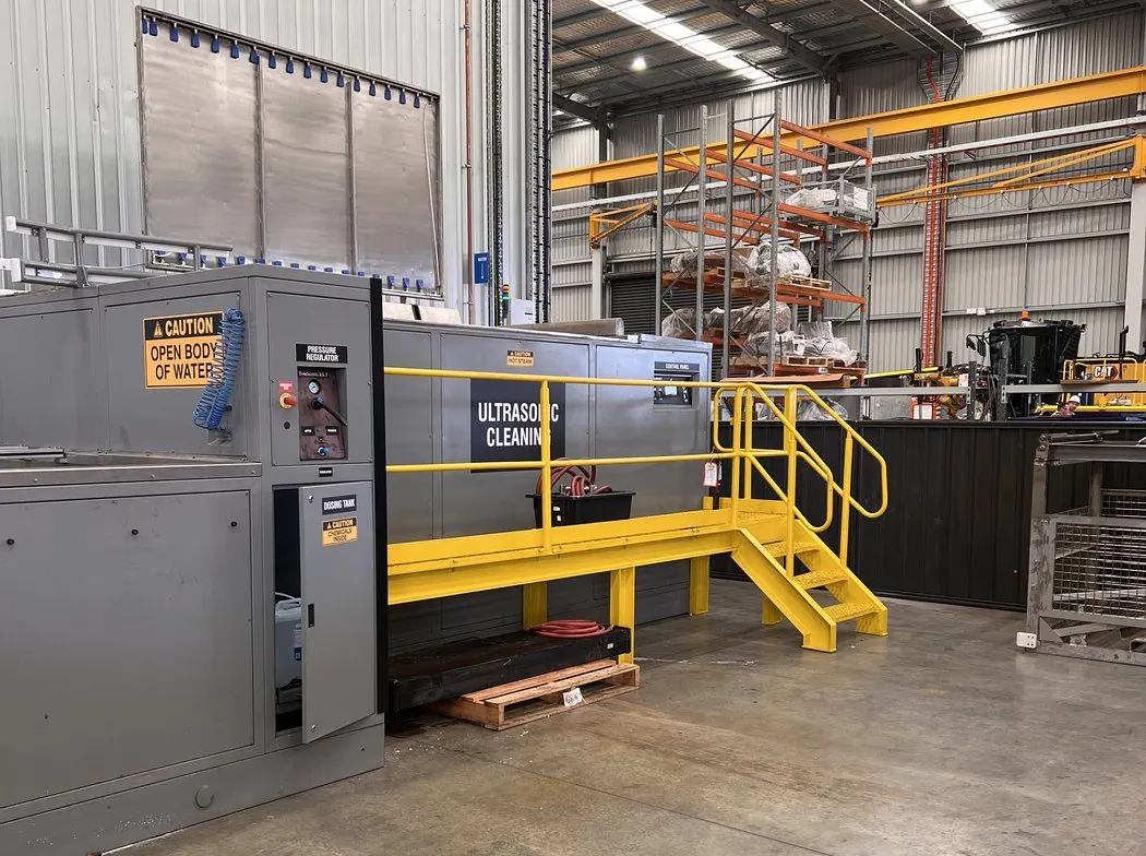 Misonics EVS 7000-PL ultrasonic cleaning tank with access stairs installed on a heavy plant workshop floor