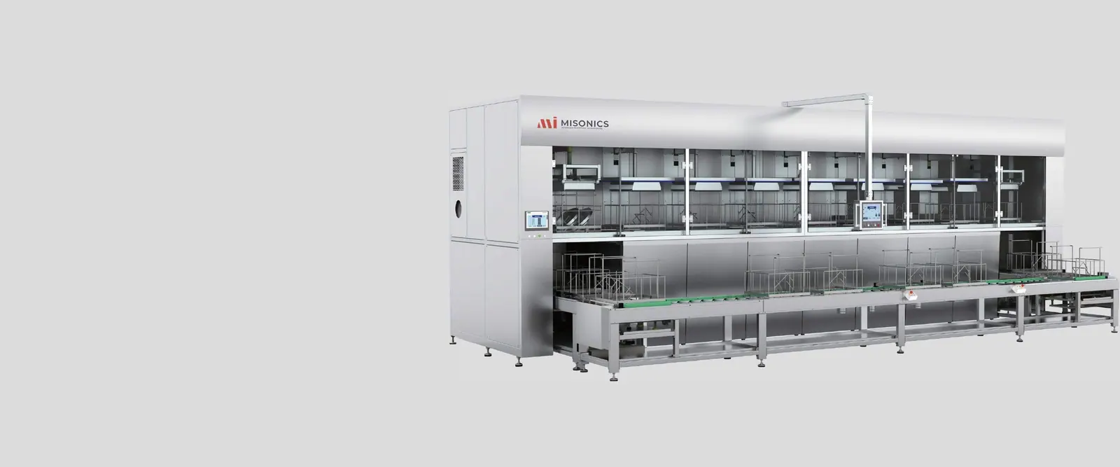 Misonics CM series multi-stage ultrasonic cleaning line — enclosed process stages above, conveyor transport running the length of the machine below