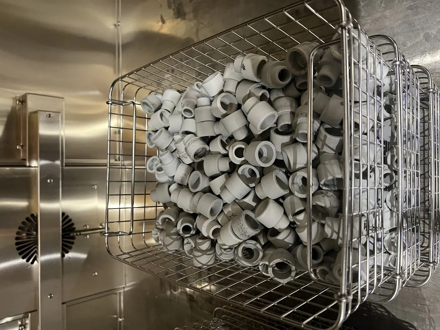 Ceramic insulator bushes basketed for ultrasonic cleaning