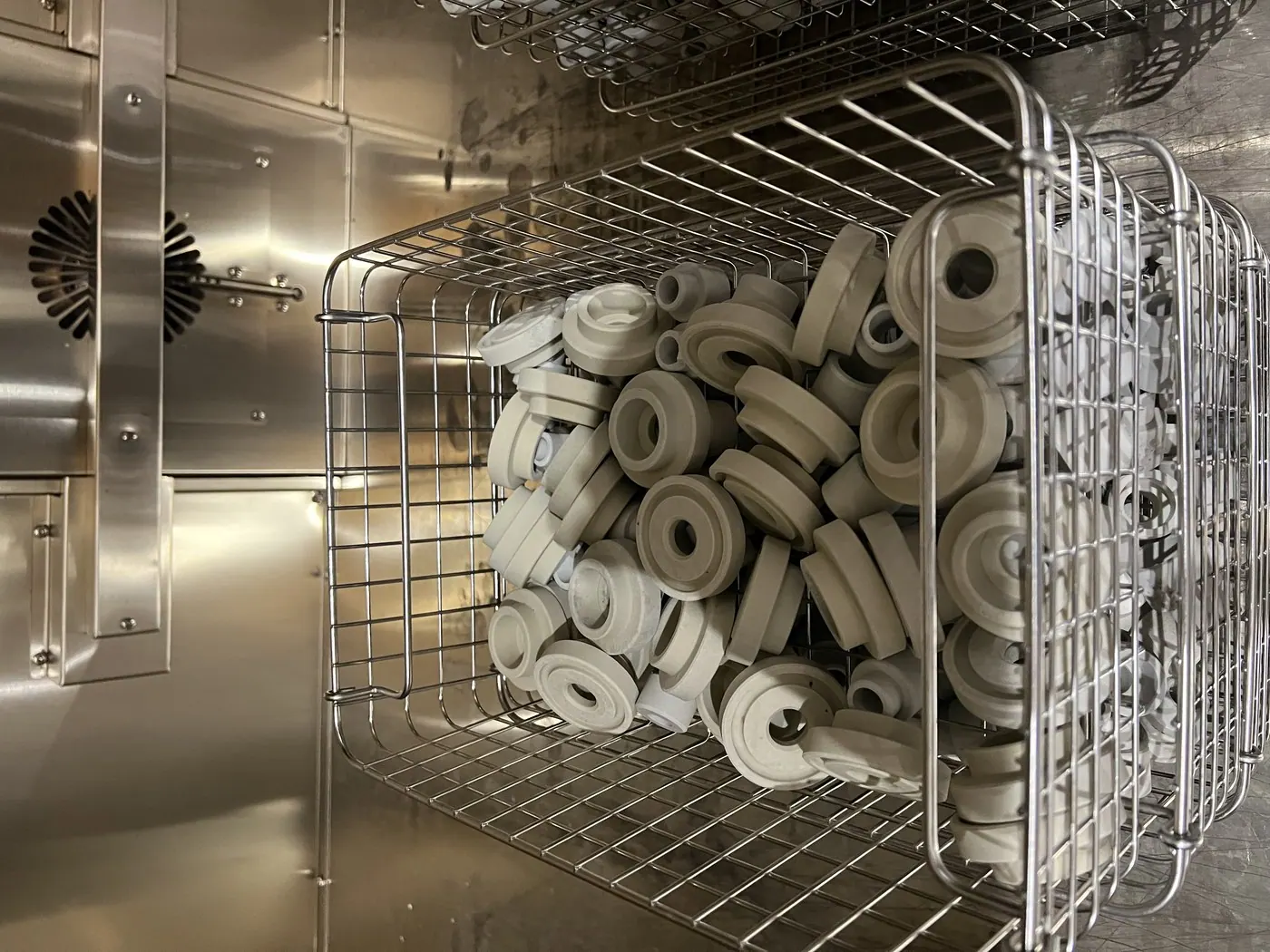 Ceramic insulator rings loaded in a stainless basket inside the tank