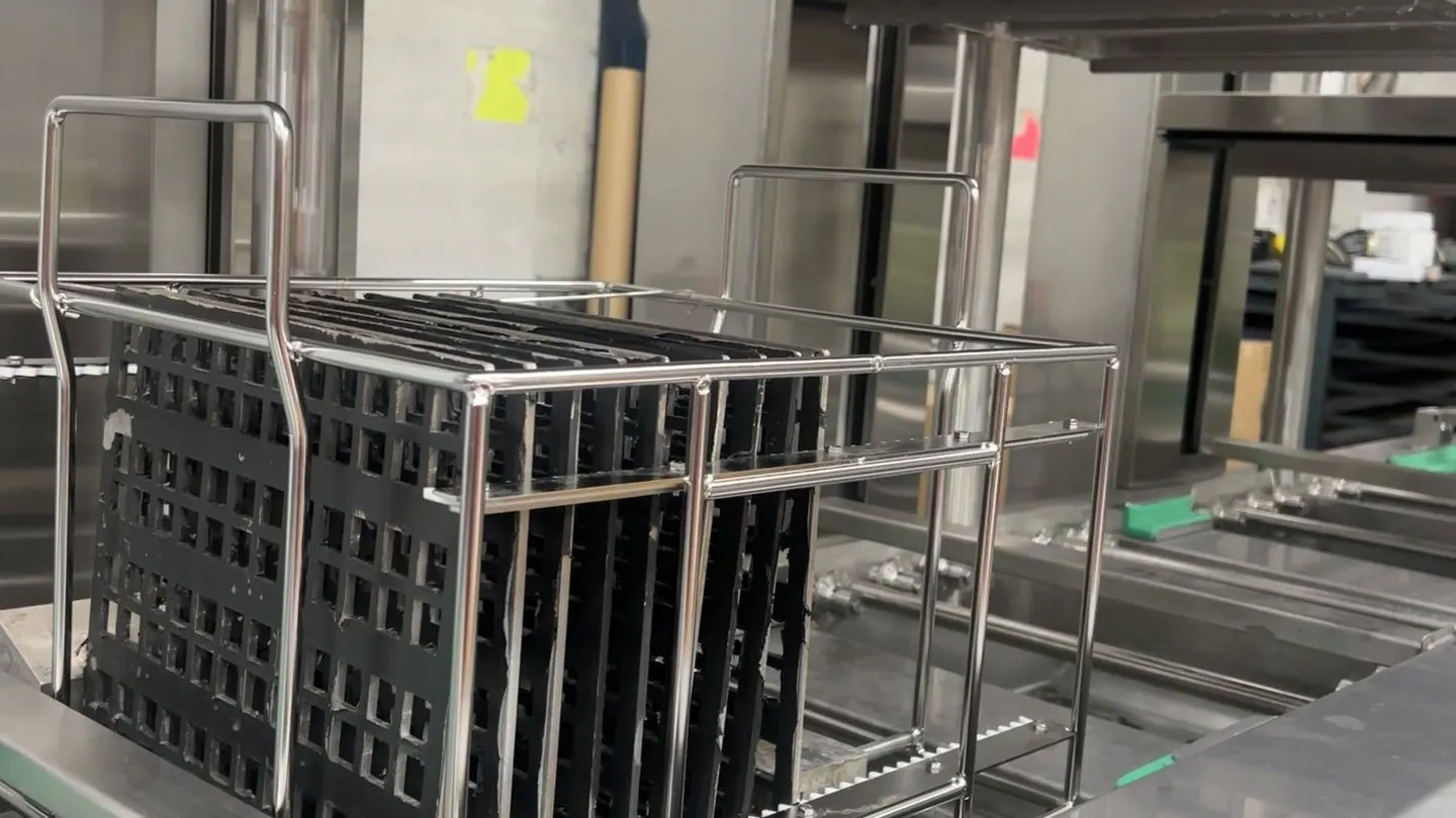 A rack of parts held above the ultrasonic wash tank of a Misonics Sono L-130 line
