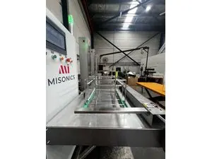 Misonics SonoLine automated ultrasonic cleaning line — Along the line, baskets staged over the tanks