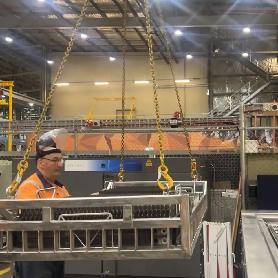 Operator lowering a loaded basket into an EVS 1500 industrial ultrasonic tank at a Melbourne rail depot